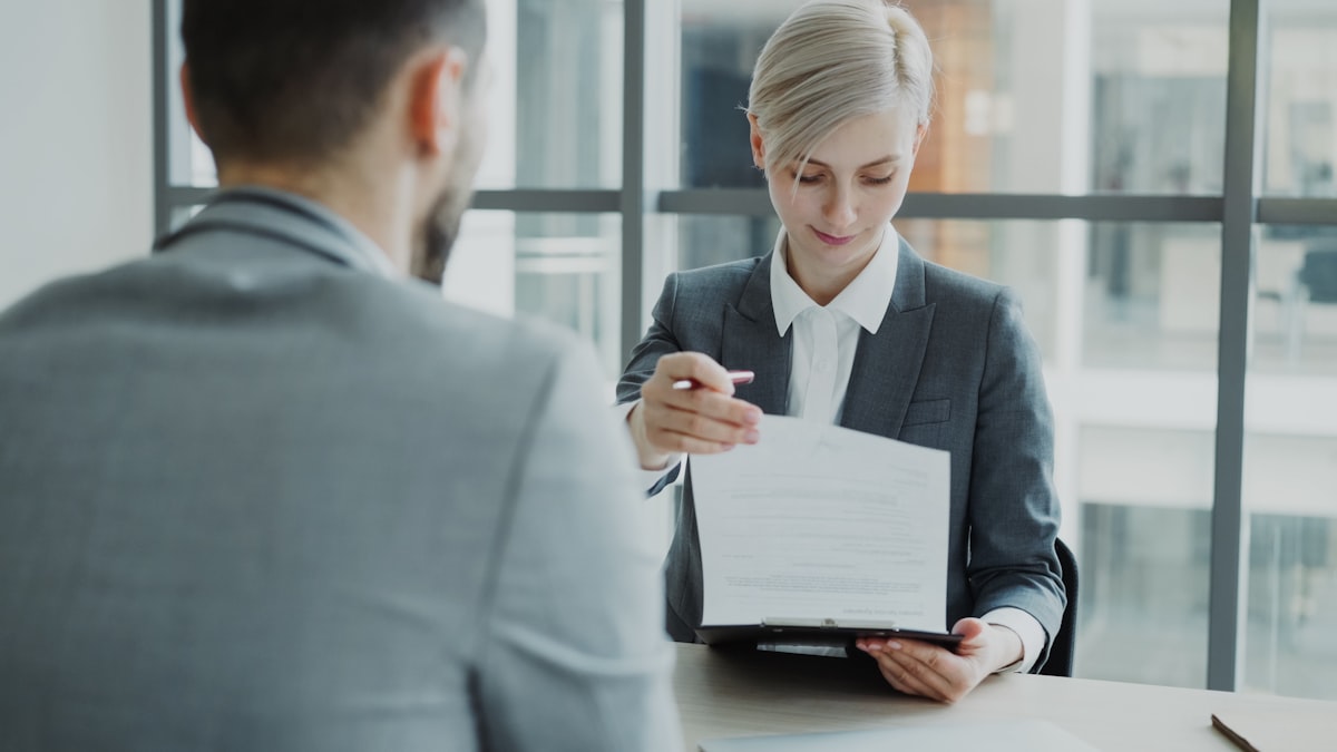 An HR manager reviewing a document with a job candidate