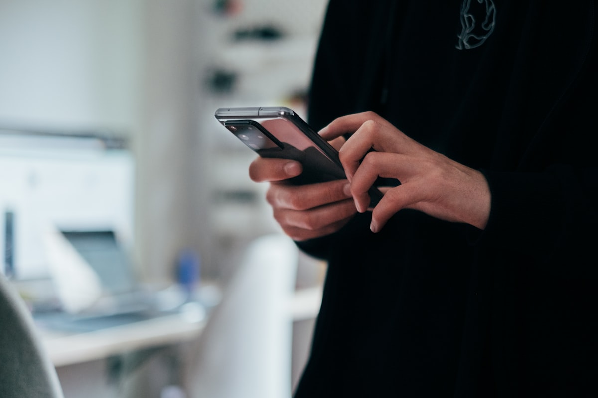 A person holding a smartphone showing a messaging app